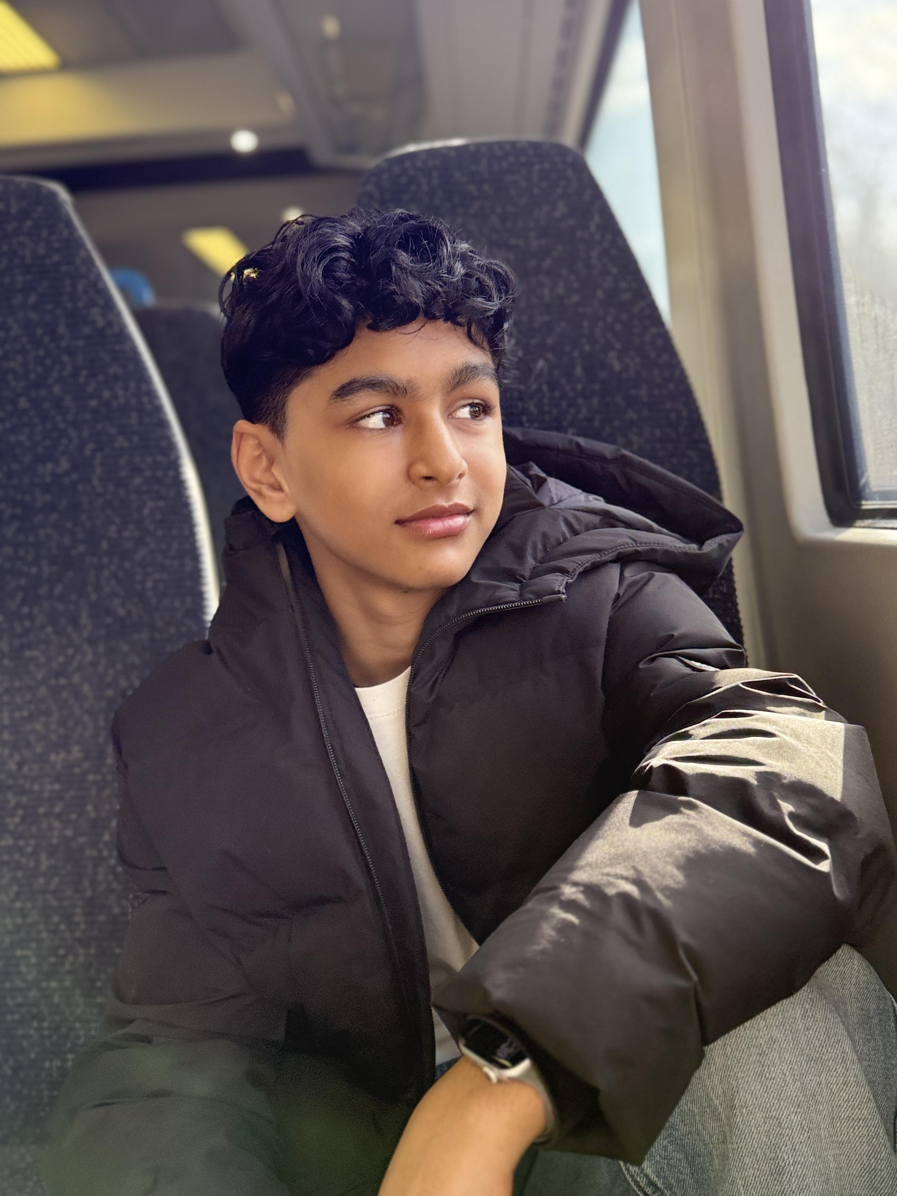 Tanay Joshi seated on a train looking outside the window
